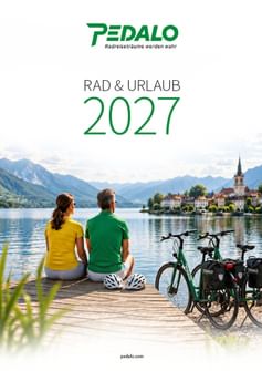 Pedalo Katalog 2027 zeigt Paar in gelben und grünen Shirts auf Steg am See mit Fahrrädern, Blick auf Alpendorf mit Kirchturm.