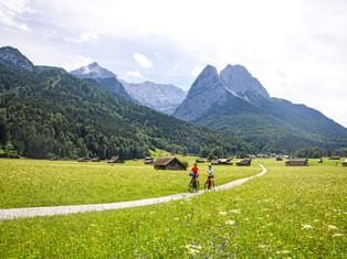 Radfahrer auf Radweg bei Garmisch mit Bergen im Hintergrund