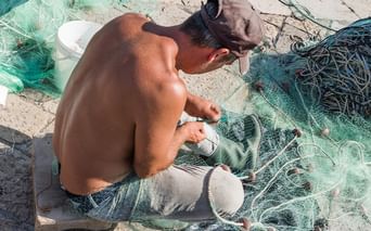 Fischer repariert sein Fischernetz im Hafen von Gallipoli