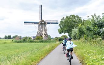 Cyclist in front of a windmill