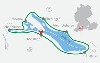 Karte des Bodensees mit grünem Radweg um den See. Städte Konstanz, Friedrichshafen, Radolfzell markiert. Kleine Deutschland-Karte.