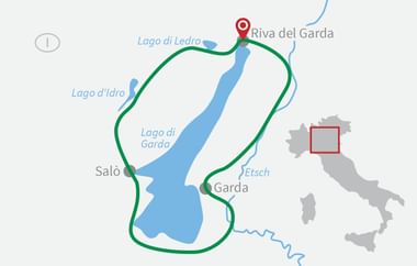 Karte mit grüner Radroute rund um den Gardasee mit Riva del Garda am nördlichen Ende. Orte Salò, Garda und Etsch sind entlang der Route markiert.