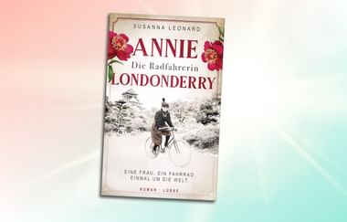 Buchcover mit Frau auf Fahrrad in Vintage-Fotografie. Titel 'Annie Londonderry Die Radfahrerin' von Susanna Leonard mit rosa Blüten.