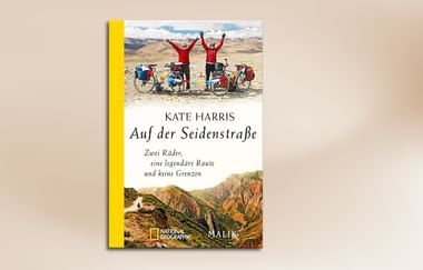 Buchcover mit Radfahrern mit erhobenen Armen in Wüstenlandschaft und Berggelände. Titel 'Auf der Seidenstraße' von Kate Harris mit gelbem Buchrücken.