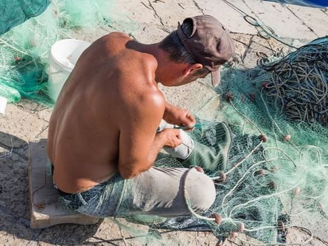 Fischer repariert sein Fischernetz im Hafen von Gallipoli