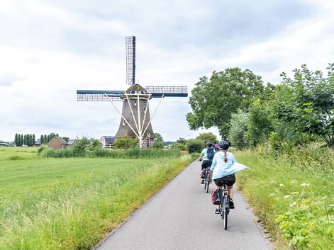 Cyclist in front of a windmill